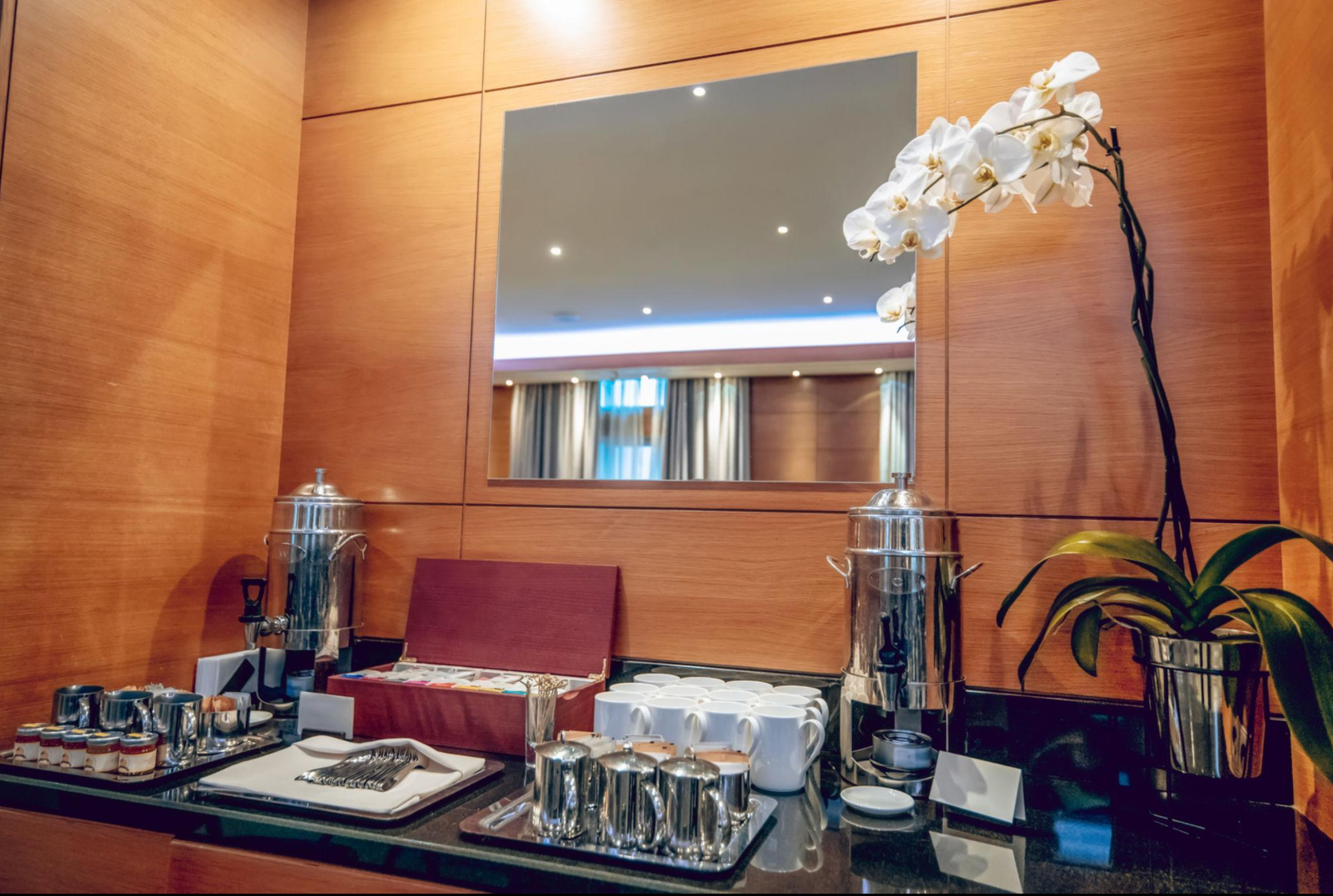 Spotless corporate refreshment station with polished surfaces and neatly arranged mugs.